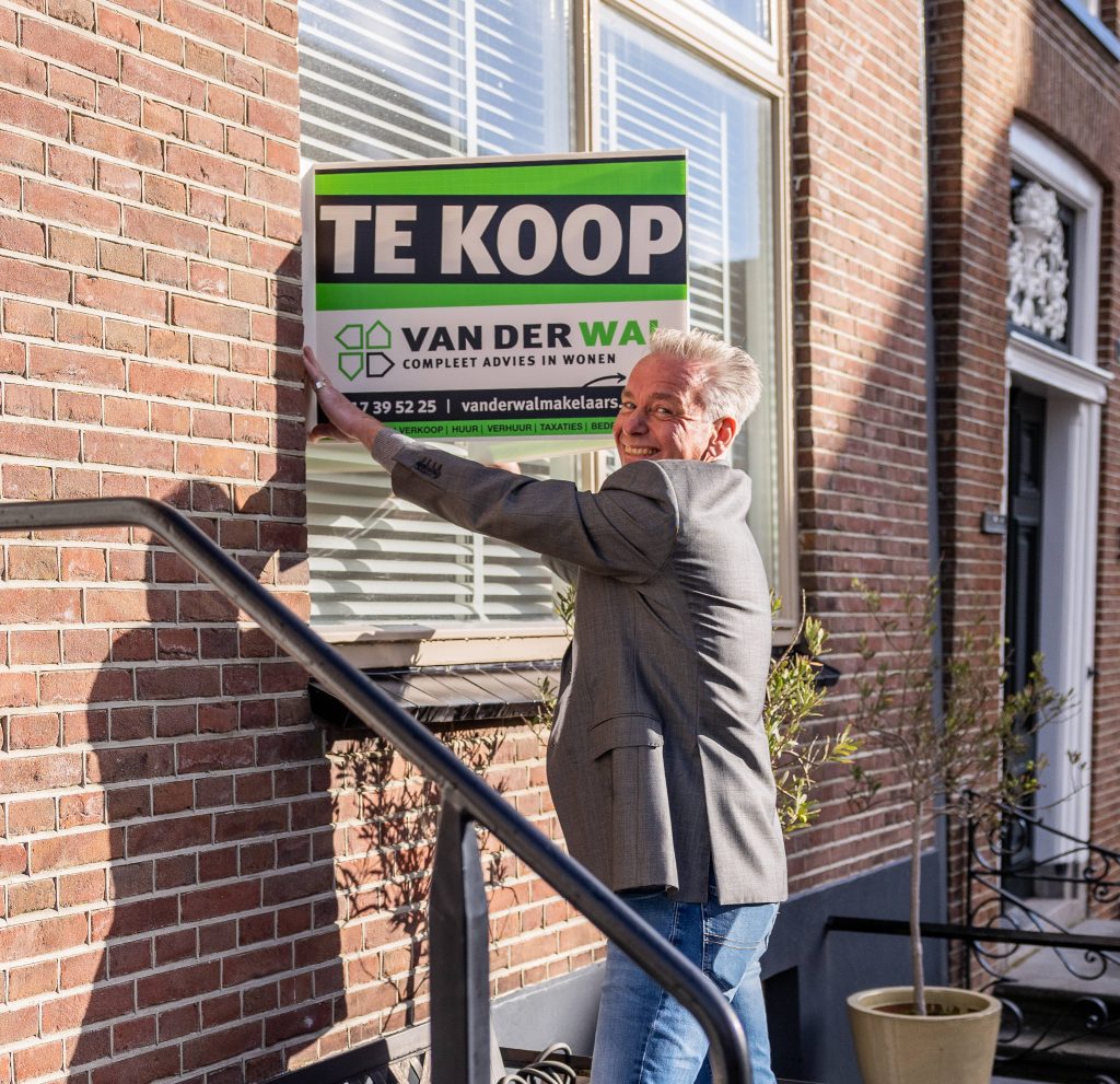 Jeroen Zaagemans plaatst een te koop-bord van Van der Wal Makelaars.